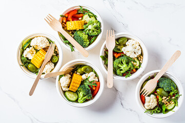 Vegan vegetable salad in paper take away bowls. Eco-friendly recyclable tableware, zero waste...