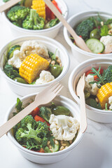 Vegan vegetable salad in paper take away bowls. Eco-friendly recyclable tableware, zero waste concept.