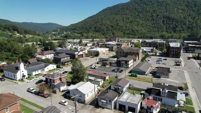 aerial push into pineville kentucky with church in foreground, small town america, hometown, small town usa, middle america in the suburbs