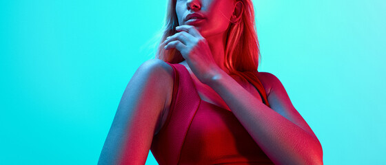 Young fitness woman's hand. Closeup portrait of attractive blond sports girl in red sportswear on bright neon creative light