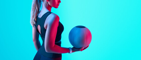 Portrait of a fit woman standing holding a medicine ball. Copy Free space. Slim caucasian cross fit...