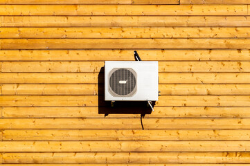 air conditioning on the wall of a log house