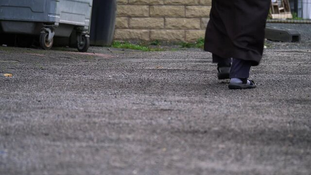Man in traditional Muslim dress walks on street