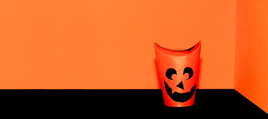 Obraz premium Happy Halloween party concept. Eco-friendly Halloween decoration with devil face on orange background. Scary face with smile. Copy space, free text, minimalism, vintage, soft focus
