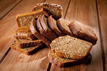 Bread made from natural products, on live sourdough, without baker's yeast, cut into skibbles on a wooden table surface.