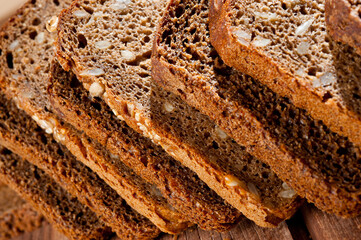 Bread made from natural products, on live sourdough, without baker's yeast, cut into skibbles on a wooden table surface.