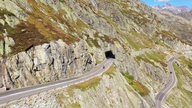 Aerial drone footage of a motorcycle driving along the Susten pass between the cantons of Bern and Uri in the alps in summer in Switzerland
