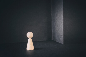 Concept image of getting stuck dead end situation. Wooden figure standing in front of wall with no...