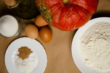 Concept homemade fall baking with pumpkin and food ingredients. Cooking pumpkin pie. Ripe pumpkin, flour, eggs, spices, baking powder, sugar, oil. Step by step instructions. Step 1.