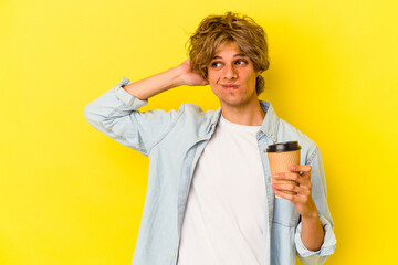 Young caucasian man with makeup holding a take away coffee isolated on yellow background  touching back of head, thinking and making a choice.