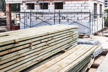 Storage of boards and building materials at the construction site. Preparation of material for building a house from aerated concrete.