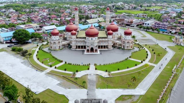 Aerial video of the Baitul Makmur Grand Mosque, West Aceh, looking at the front of the main road and mosque grounds with the drone moving forward