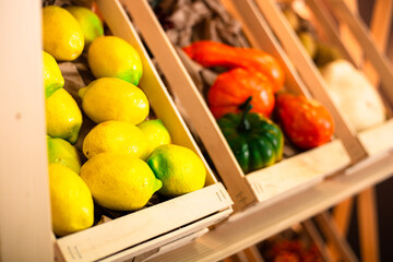 Lemons and vegetables on a shelf in boxes
