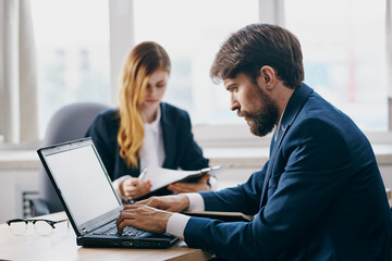 Obraz premium business man and woman in the office in front of a laptop career network officials