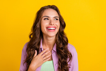 Portrait of attractive cheerful wavy-haired girl laughing funny joke isolated over bright yellow color background