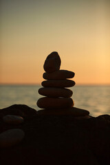 Zen stones on a ocean sea cliff in sunset sunrise time.