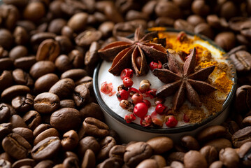 Cup of coffee with spices among coffee beans