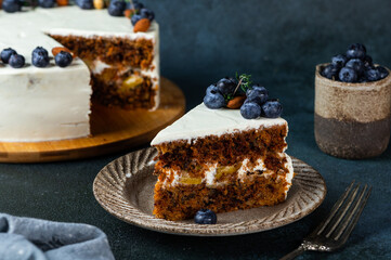 piece of carrot cake with walnuts and blueberry on dark wood background. Local food. Traditional american cake. Cake for thanksgiving day. Christmas cake.