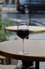 A glass of red wine on the summer terrace of a Parisian restaurant