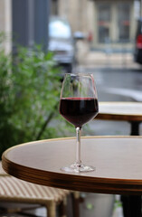 A glass of red wine on the summer terrace of a Parisian restaurant