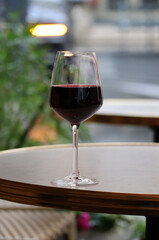 A glass of red wine on the summer terrace of a Parisian restaurant