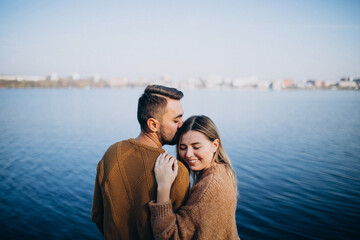 Young couple in park standing by the river