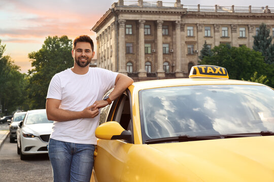 Handsome taxi driver near car on city street
