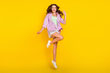 Full size photo of positive cheerful young woman jump up enjoy weekend smile isolated on yellow color background