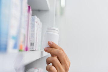 cropped view of pharmacist taking bottle with medication