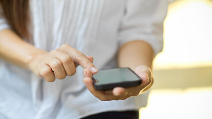 Woman's hands hold cellphone, using calculator app on mobile phone