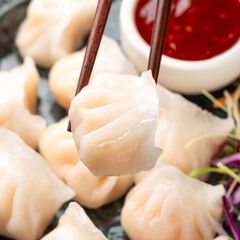Traditional Asian Prawn or shrimp dumplings hakau, ha kauw or har gow. Served with cabbage, carrot salad and soy and sweet chilli sauce