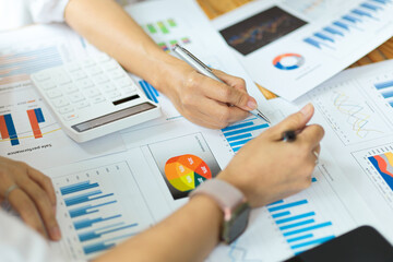 Businesspeople working on financial reports, graphs, charts