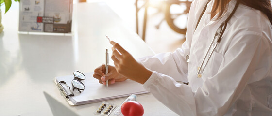 Asian female doctor or pharmacist writes a medication prescription