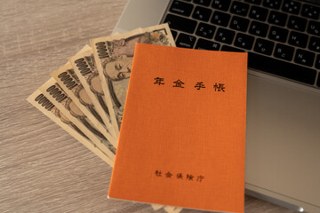 年金手帳と紙幣とパソコン