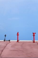 electric scooter and red telescope, tourist equipment, vacations, industrial landscape.