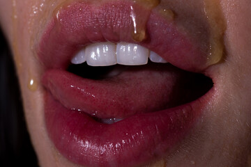 Sexy full lips. Honey dripping on sexy girl lips. Eating honey. Healthy food concept.