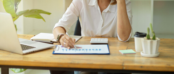 Senior businesswoman or female executive working at her desk in a modern office room