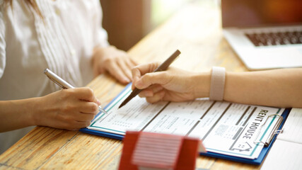 Senior woman signing her name to formalise the house rental agreement