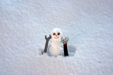 Winter, snowman concept of building and repair. Little snowman with builder tools. Happy winter holiday and celebration.