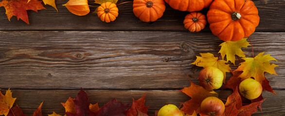 Framework with pumpkins and fall leaves on wooden background. Top view.