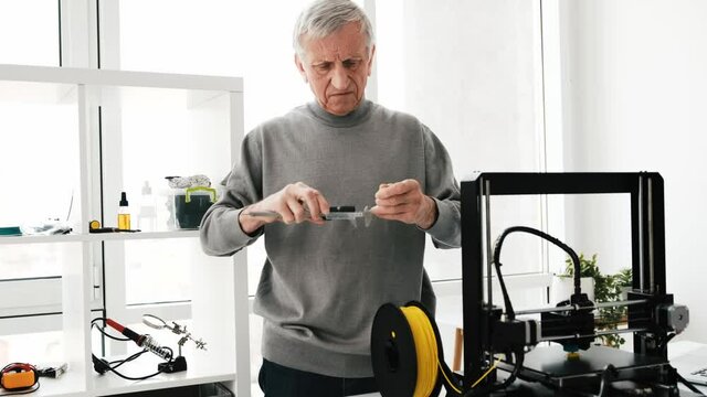 Adult man measuring size of model detail developed with 3D printer