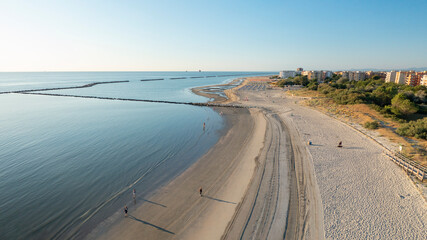 Aerial shot of sandy beach with umbrellas, typical adriatic shore.Summer vacation concept.Lido...