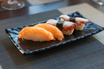 Traditional japanese nigiri sushi with salmon  and sushi with octopus on black plate.