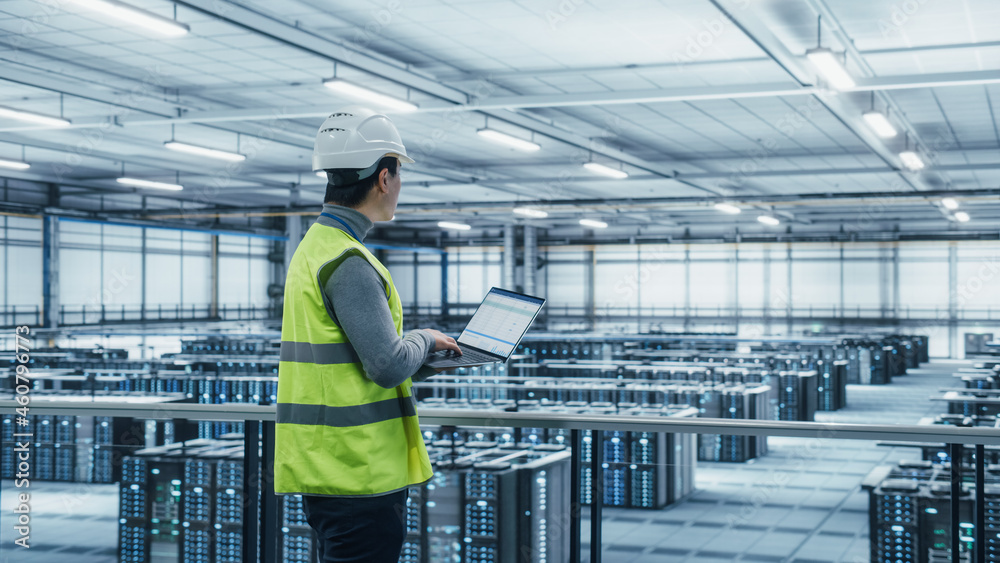 Poster Data Center Engineer in High Visibility Vest Using Laptop Computer. Server Farm Cloud Computing Facility with Asian Male System Administrator Working with Data Protection Network for Cyber Security.