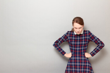 Portrait of angry disgruntled girl holding hands on hips