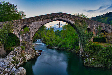 Fototapeta na wymiar old roman bridge over the river at Cangas de Onís, long exposure
