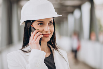 Young business woman wearing hard hat at building object