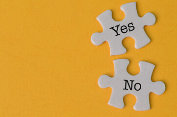 Obraz premium Jigsaw puzzle with text YES and NO isolated on a yellow background