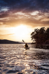 Fototapeta na wymiar Adventurous Woman on Sea Kayak paddling in the Pacific Ocean. Dramatic Sunset Sky Art Render. Taken near Victoria, Vancouver Islands, British Columbia, Canada. Concept: Sport, Adventure