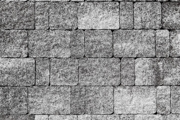 The wall is faced with stones of different sizes with random uneven staining.